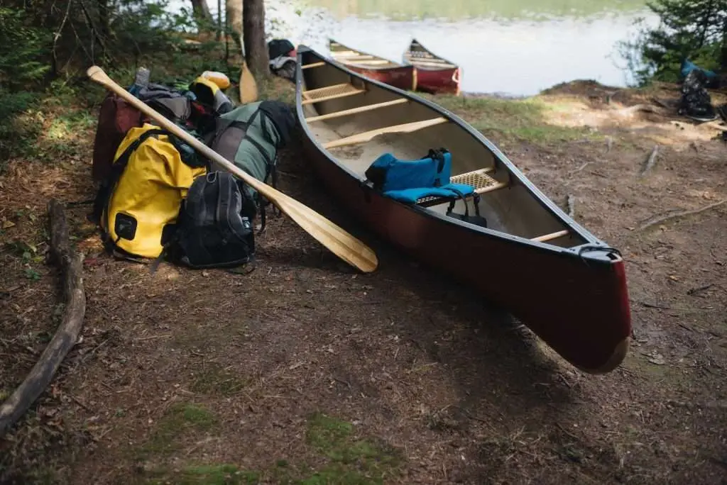 Canoe and camping equipment beside lake, Algonquin, Ontario, Canada