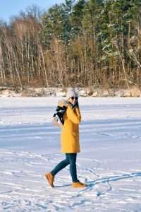 Woman holding ice skates ready to ice skate on frozen lake
